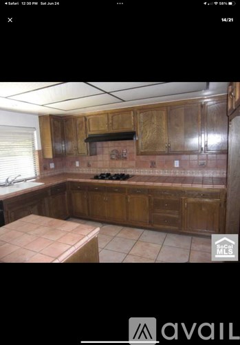A kitchen with wooden cabinets and a tiled backsplash.