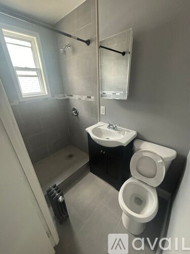 A bathroom with a toilet, sink, and shower.