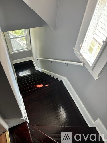 A staircase with a wooden floor and white railings.
