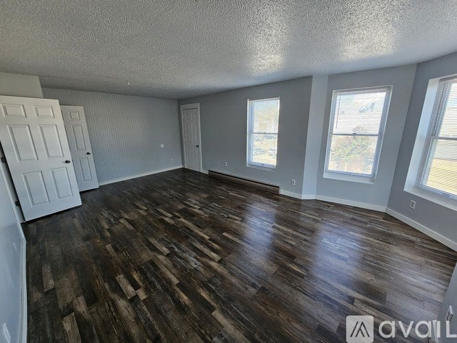 A room with wooden flooring and white walls.