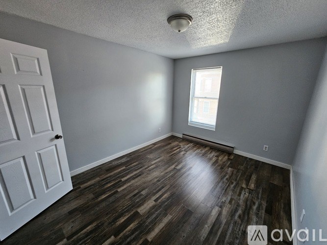A room with wooden floors and a white door.