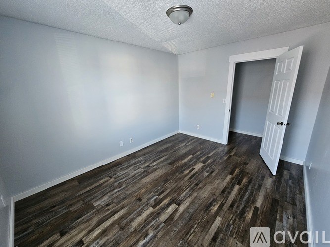 A room with wooden flooring and a white door.