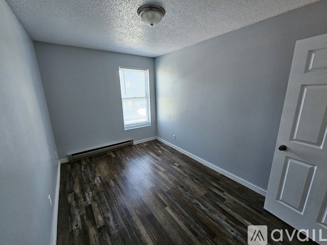 A room with wooden flooring and a window.