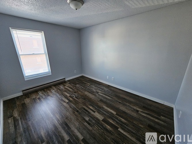 A room with wooden flooring and a window.