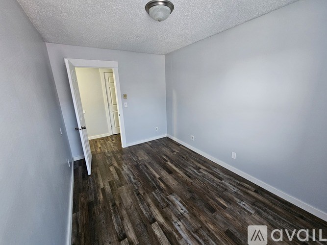 A room with wooden flooring and a white door.