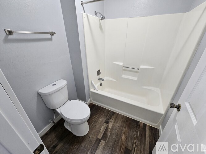 A white toilet sits next to a walk-in shower in a bathroom.