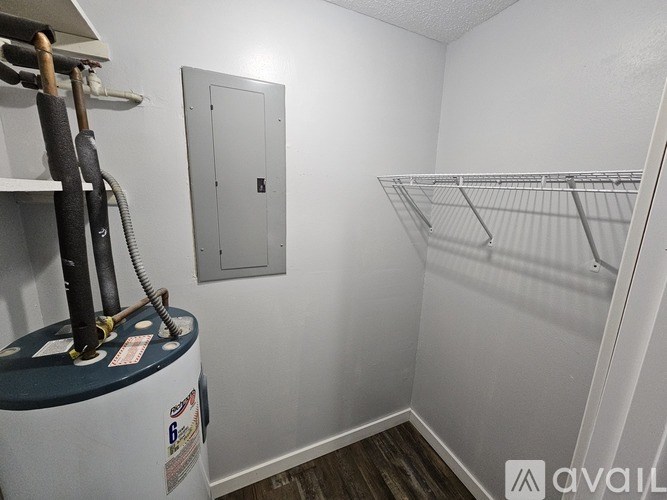 A small, white closet with a metal rack and a white door.