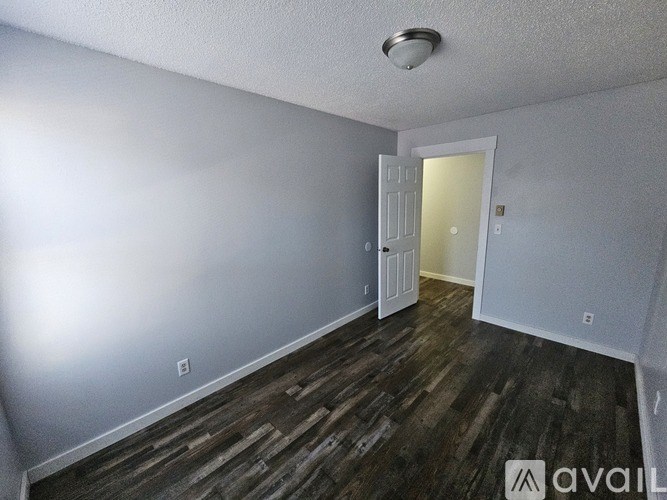 A room with wooden flooring and a white door.
