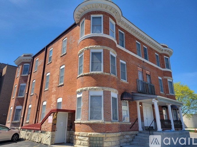 A red brick building with a balcony on the second floor.