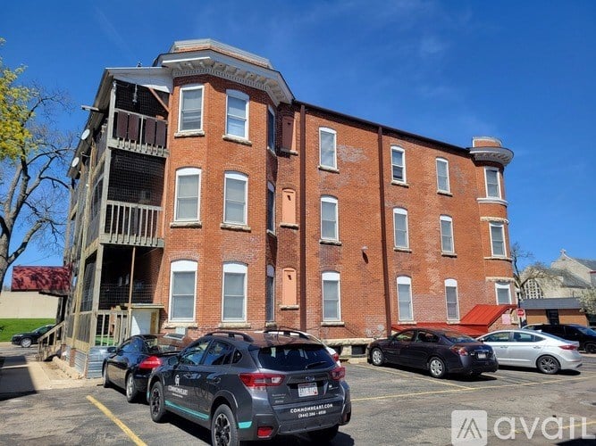 A parking lot with cars and a red brick building.