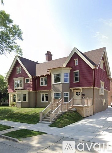 A red house with a white fence in front.