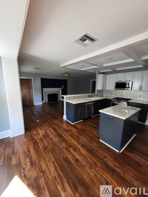 A kitchen with wooden floors and a refrigerator.