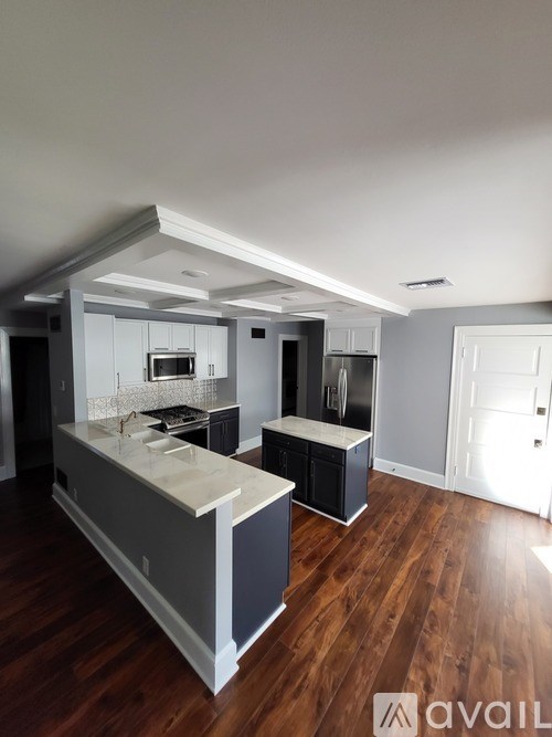 A kitchen with a refrigerator, sink, and cabinets.