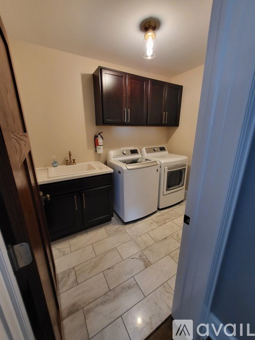 A kitchen with white appliances and dark brown cabinets.