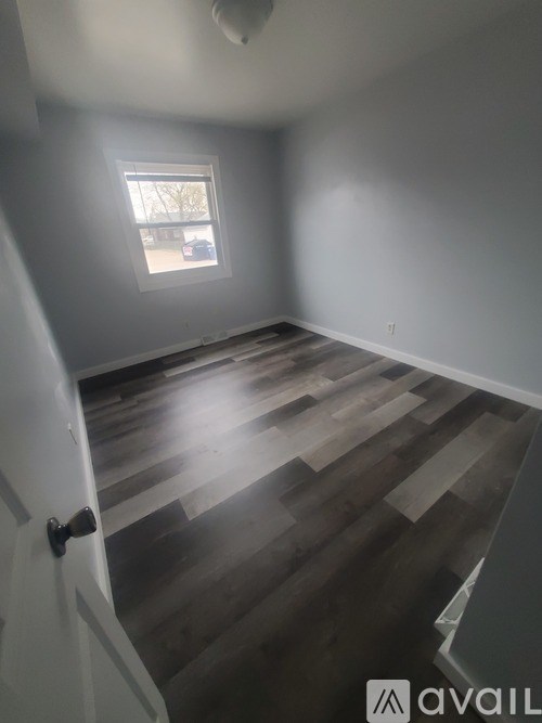 A room with wooden flooring and a window.
