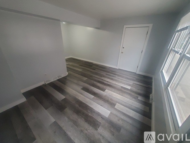 A room with a wooden floor and a white door.