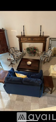 A living room with a blue couch and a wooden fireplace.