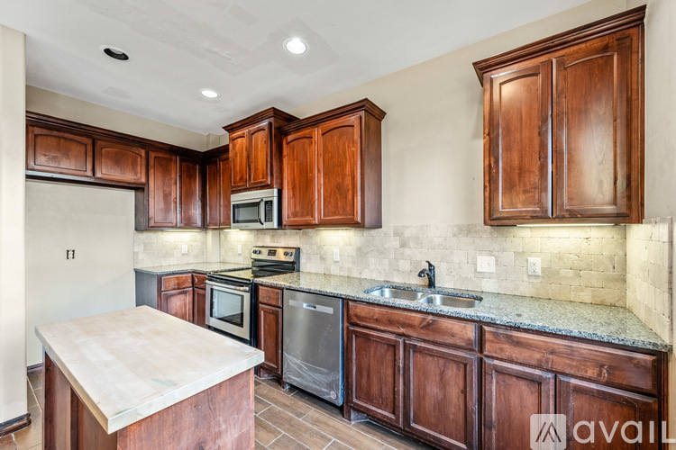 A kitchen with wooden cabinets and a stainless steel oven.