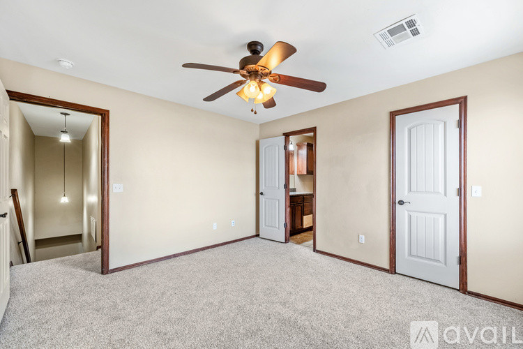 A spacious room with a ceiling fan and carpeted floor.