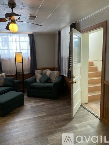 A living room with a green couch and a lamp.