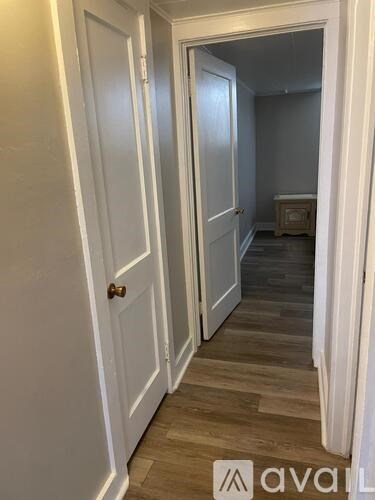 A hallway with two doors on either side and a wooden floor.