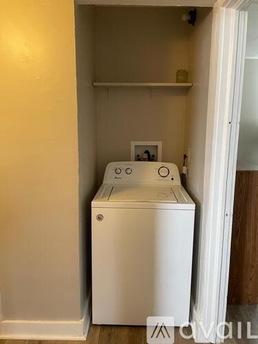 A white washing machine in a small laundry room.