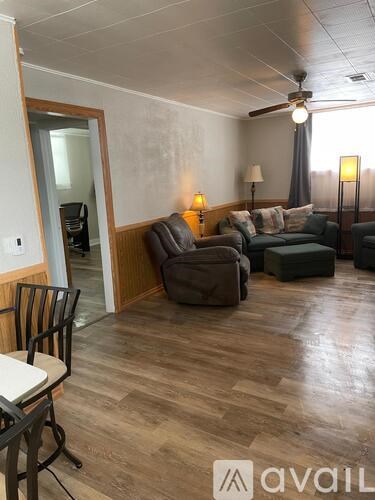 A living room with a brown couch and a wooden floor.