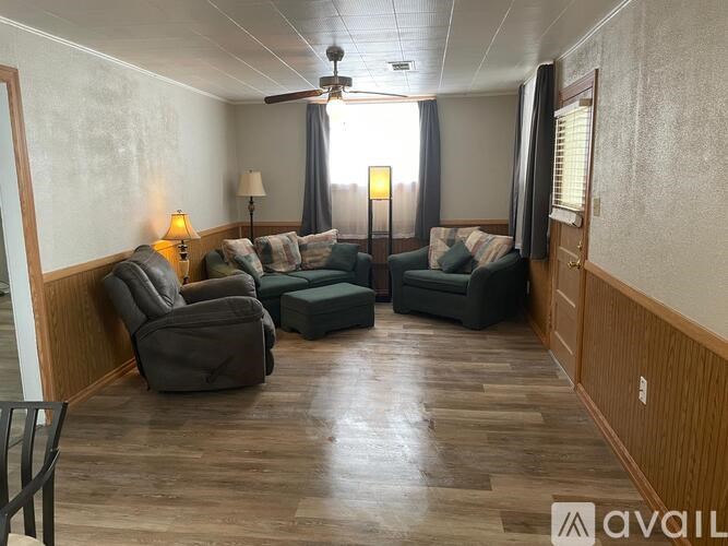 A living room with a brown floor and furniture.