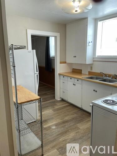 A kitchen with white cabinets and a white fridge.