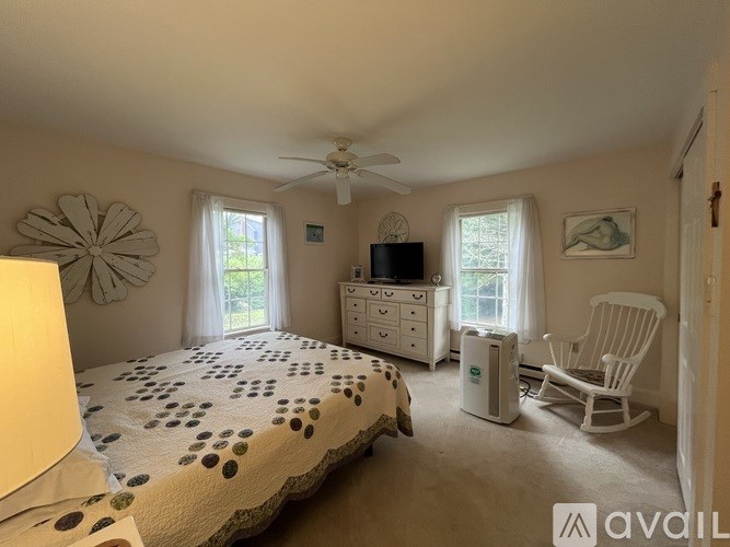 A bedroom with a bed, dresser, and chair.