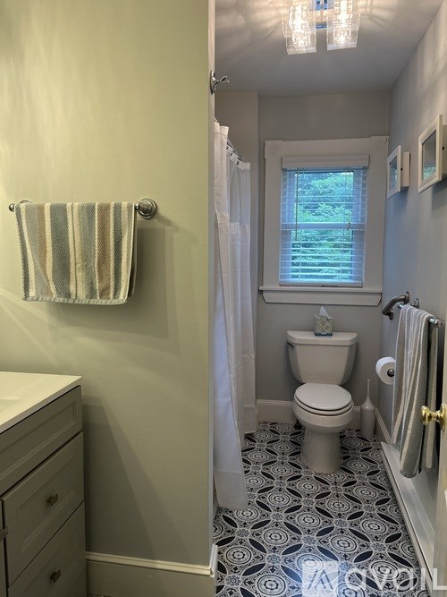 A bathroom with a toilet, a sink, and a shower.
