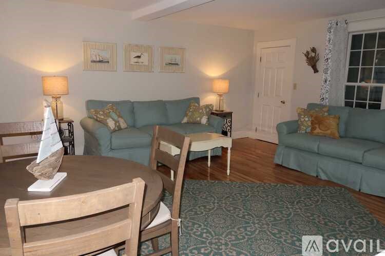 A living room with a couch, chairs, and a dining table.