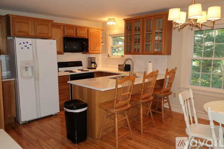 A kitchen with wooden cabinets and a white fridge.