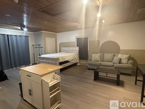 A kitchen with white cabinets and a wooden ceiling.