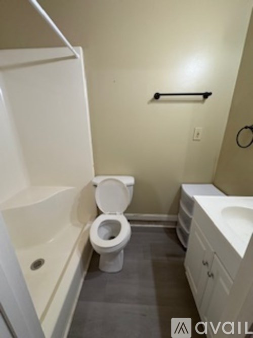 A white toilet in a small bathroom with a white bathtub and a white sink.