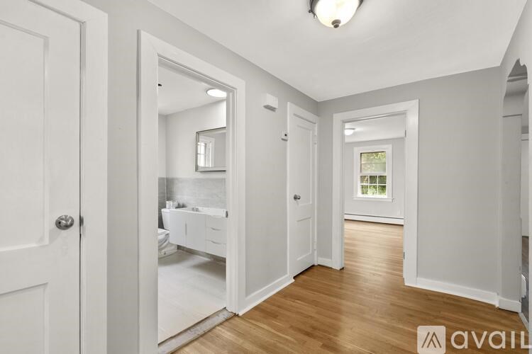 A white bathroom with a mirror and a window.