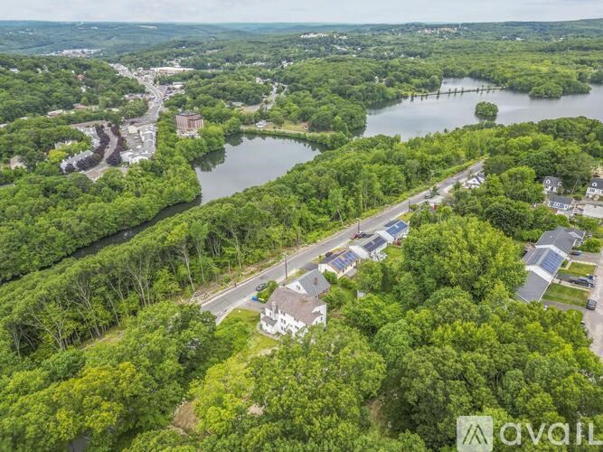 A bird's eye view of a residential area with a lake and greenery.