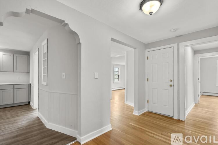 A spacious room with wooden floors and white walls.