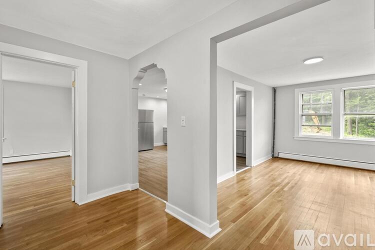 A spacious room with wooden floors and white walls.