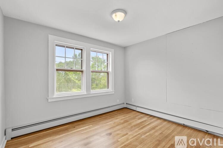 A room with a window and wooden flooring.