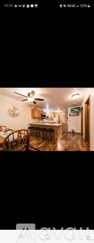 A living room with a couch, chairs, and a ceiling fan.