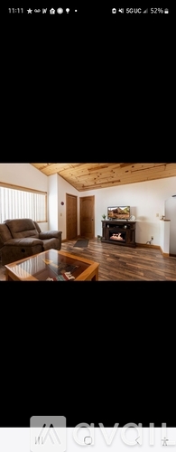 A modern living room with a wooden ceiling and a large window.