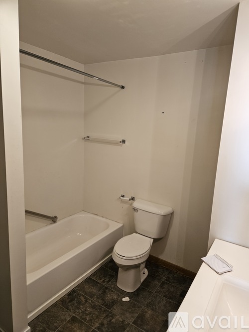A white toilet sits next to a bathtub in a bathroom.