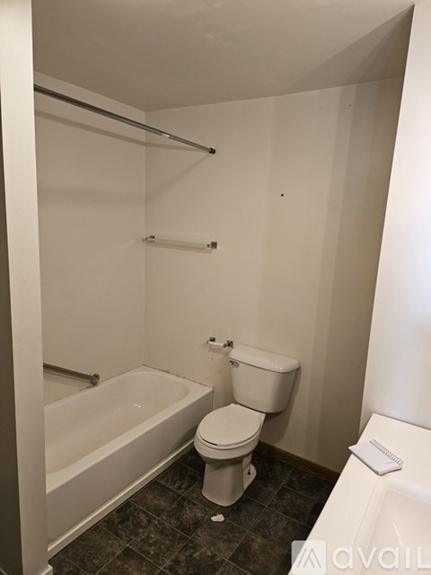 A white toilet sits next to a bathtub in a bathroom.