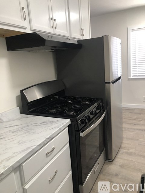 A kitchen with a black stove top oven and white cabinets.