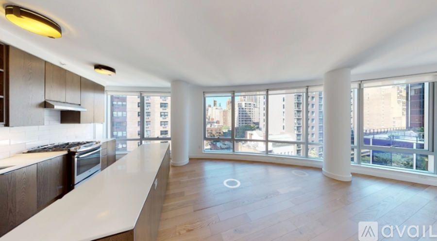 A spacious kitchen with wooden floors and a large island in the middle.