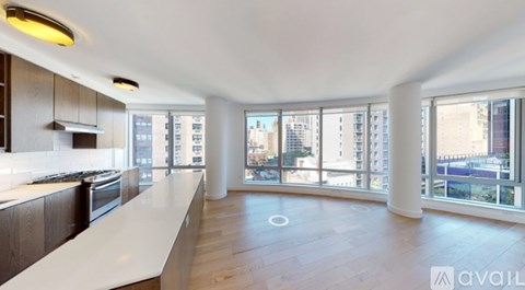 A spacious kitchen with wooden floors and a large island in the middle.