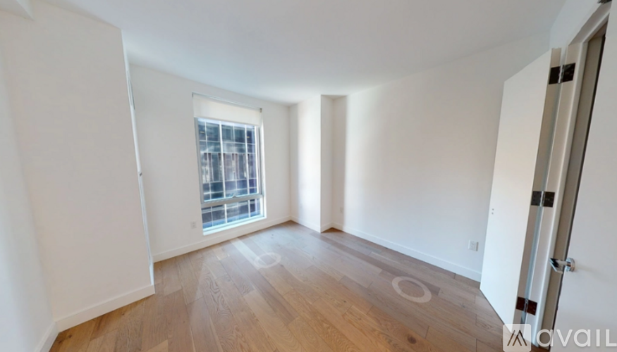 A room with a window and wooden flooring.