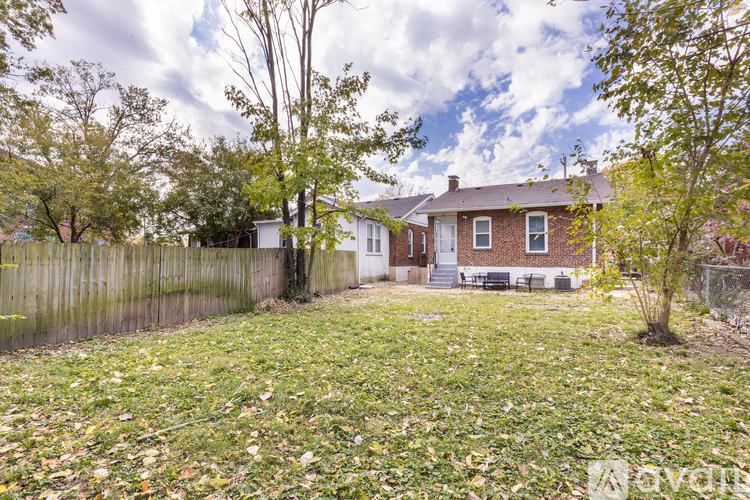 A house with a fence and trees in the yard.