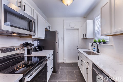 A kitchen with white cabinets and a black stove top.